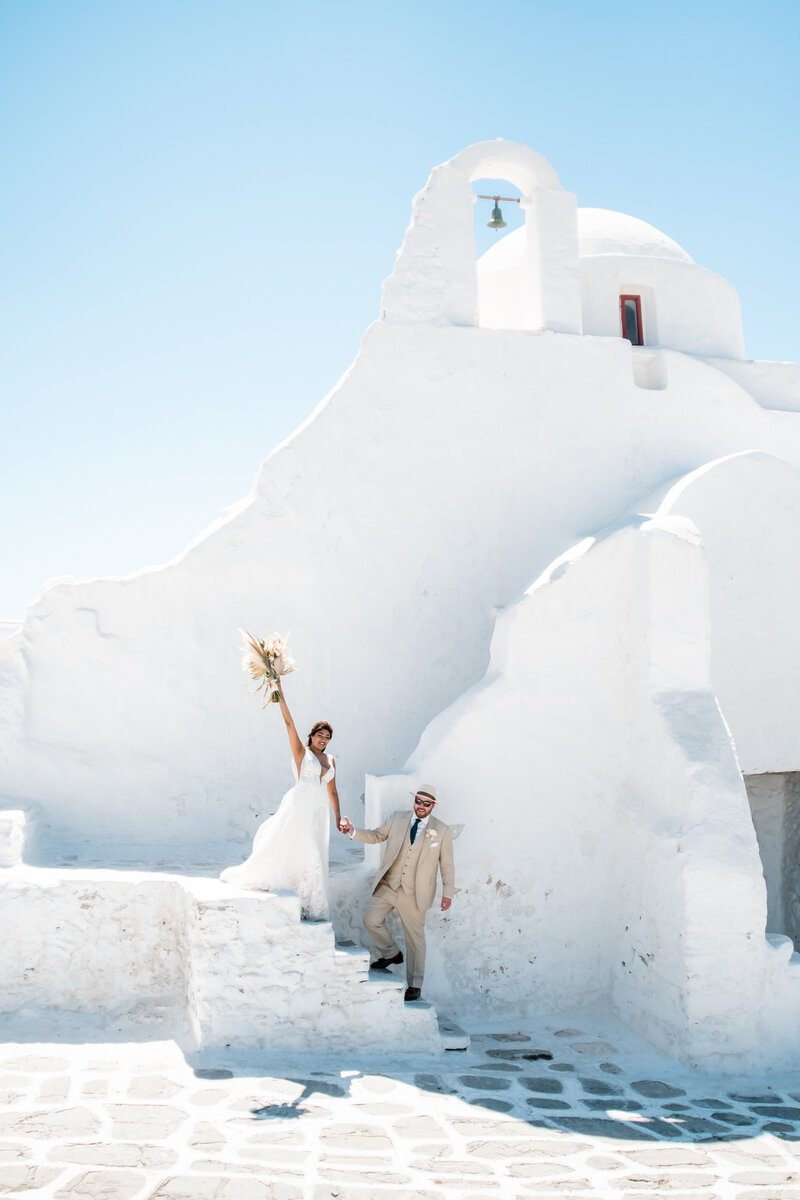 The stunning Mykonos wedding chapel Paraportiani serves as the backdrop for a destination wedding in Greece.
