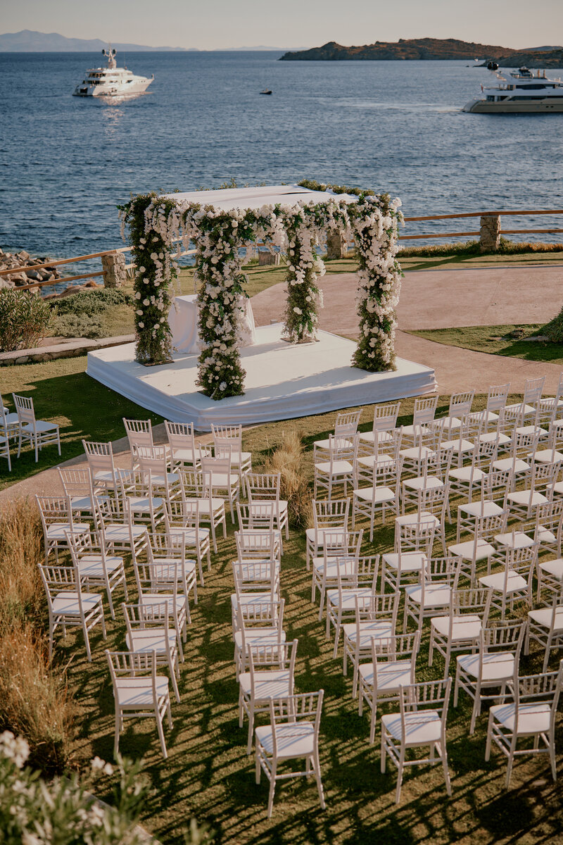 Seaside ceremony arrangement in Mykonos with elegant wedding décor, ideal for destination wedding planning