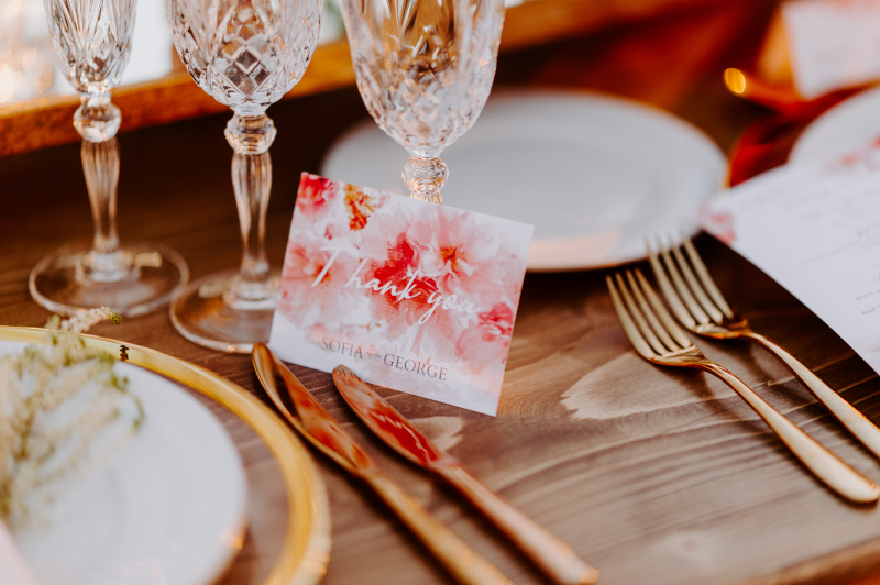 An exquisite table setting featuring a menu and goldware, set for a luxurious wedding in Mykonos, showcasing the art de la table.