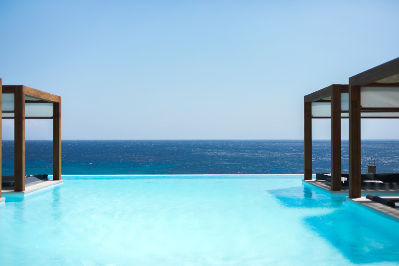 A serene pool with a lounge area, offering a breathtaking sea view - perfect for a Mykonos wedding guests accommodation hotel