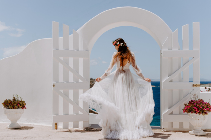 Wedding photographer capturing a Bride of a beautiful Mykonos wedding ceremony with the sea in the background.