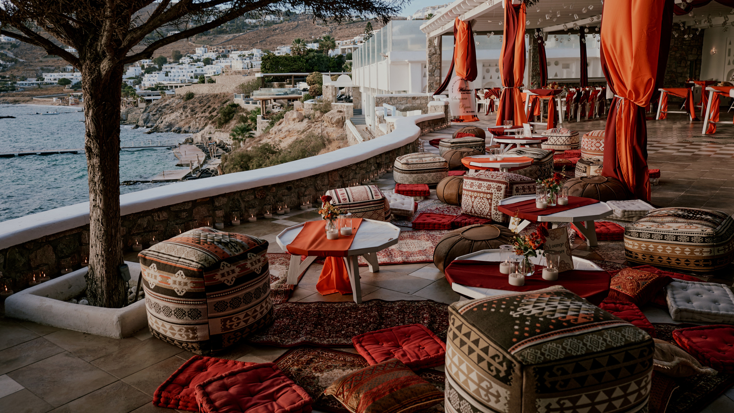 Arabian-inspired pre-wedding celebration in Mykonos with bespoke lounge décor, luxury cushions and rugs, and an exclusive seaside setting for destination wedding guests